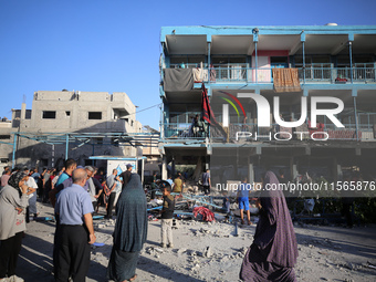 Palestinians check the grounds of a school after an Israeli air strike hits the site in Nuseirat, Gaza Strip, on September 11, 2024, amid th...