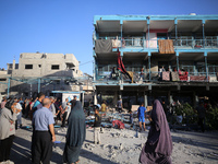 Palestinians check the grounds of a school after an Israeli air strike hits the site in Nuseirat, Gaza Strip, on September 11, 2024, amid th...