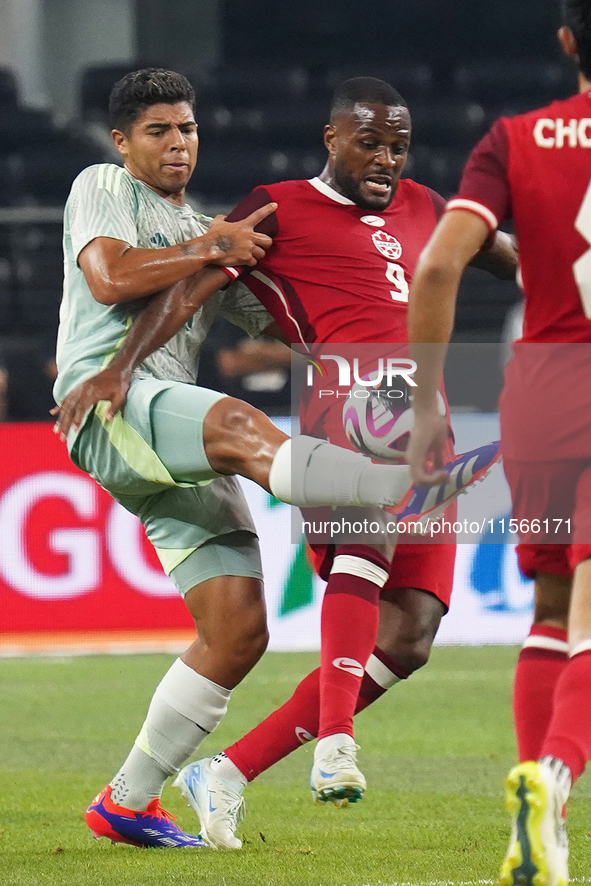 Victor Andres Guzman Olmedo #14 of Mexico and Cyle Larin #9 of Canada battle for the ball during the international friendly match between Me...