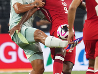 Victor Andres Guzman Olmedo #14 of Mexico and Cyle Larin #9 of Canada battle for the ball during the international friendly match between Me...