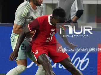 Cesar Huerta #21 of Mexico and Richie Laryea #22 of Canada battle for the ball during the international friendly match between Mexico and Ca...