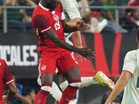 Alphonso Davies #19 of Canada jumps for the header during the international friendly match between Mexico and Canada at AT&T Stadium in Mexi...