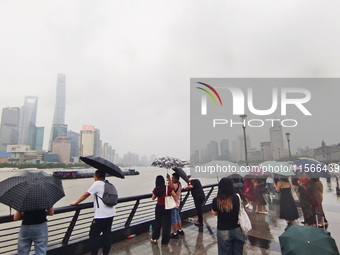 Tourists view the area amid heavy rain affected by a typhoon in Shanghai, China, on September 10, 2024. (