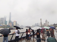 Tourists view the area amid heavy rain affected by a typhoon in Shanghai, China, on September 10, 2024. (