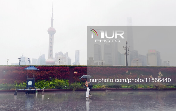 Tourists view the area amid heavy rain affected by a typhoon in Shanghai, China, on September 10, 2024. 