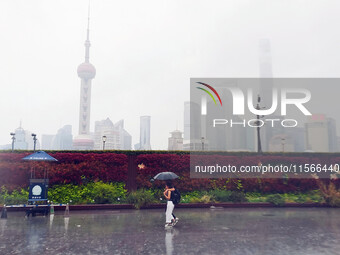 Tourists view the area amid heavy rain affected by a typhoon in Shanghai, China, on September 10, 2024. (