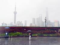 Tourists view the area amid heavy rain affected by a typhoon in Shanghai, China, on September 10, 2024. (