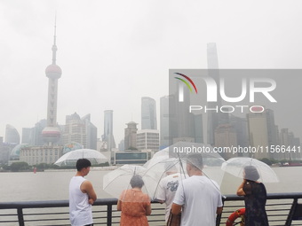 Tourists view the area amid heavy rain affected by a typhoon in Shanghai, China, on September 10, 2024. (