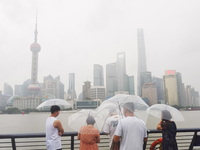 Tourists view the area amid heavy rain affected by a typhoon in Shanghai, China, on September 10, 2024. (