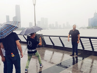 Tourists view the area amid heavy rain affected by a typhoon in Shanghai, China, on September 10, 2024. (