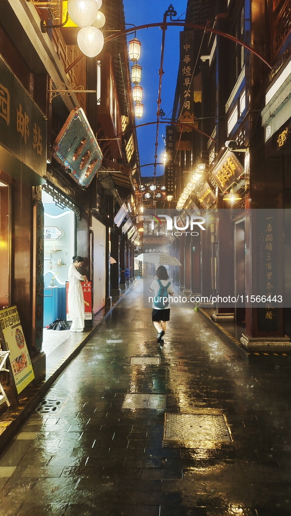 Tourists view the area amid heavy rain affected by a typhoon in Shanghai, China, on September 10, 2024. 