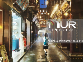 Tourists view the area amid heavy rain affected by a typhoon in Shanghai, China, on September 10, 2024. (