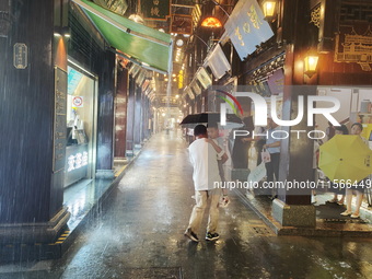 Tourists view the area amid heavy rain affected by a typhoon in Shanghai, China, on September 10, 2024. (