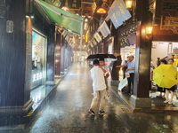 Tourists view the area amid heavy rain affected by a typhoon in Shanghai, China, on September 10, 2024. (