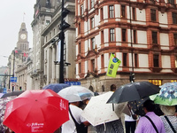 Tourists view the area amid heavy rain affected by a typhoon in Shanghai, China, on September 10, 2024. (