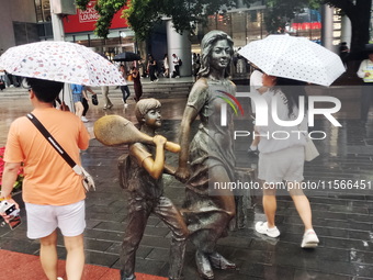 Tourists view the area amid heavy rain affected by a typhoon in Shanghai, China, on September 10, 2024. (