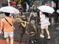 Tourists view the area amid heavy rain affected by a typhoon in Shanghai, China, on September 10, 2024. (