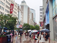 Tourists view the area amid heavy rain affected by a typhoon in Shanghai, China, on September 10, 2024. (