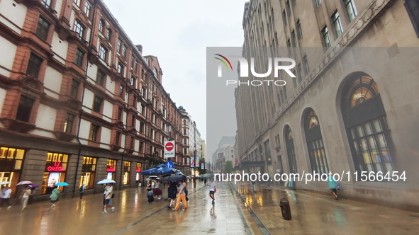 Tourists view the area amid heavy rain affected by a typhoon in Shanghai, China, on September 10, 2024. 