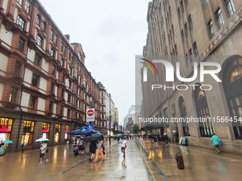 Tourists view the area amid heavy rain affected by a typhoon in Shanghai, China, on September 10, 2024. (