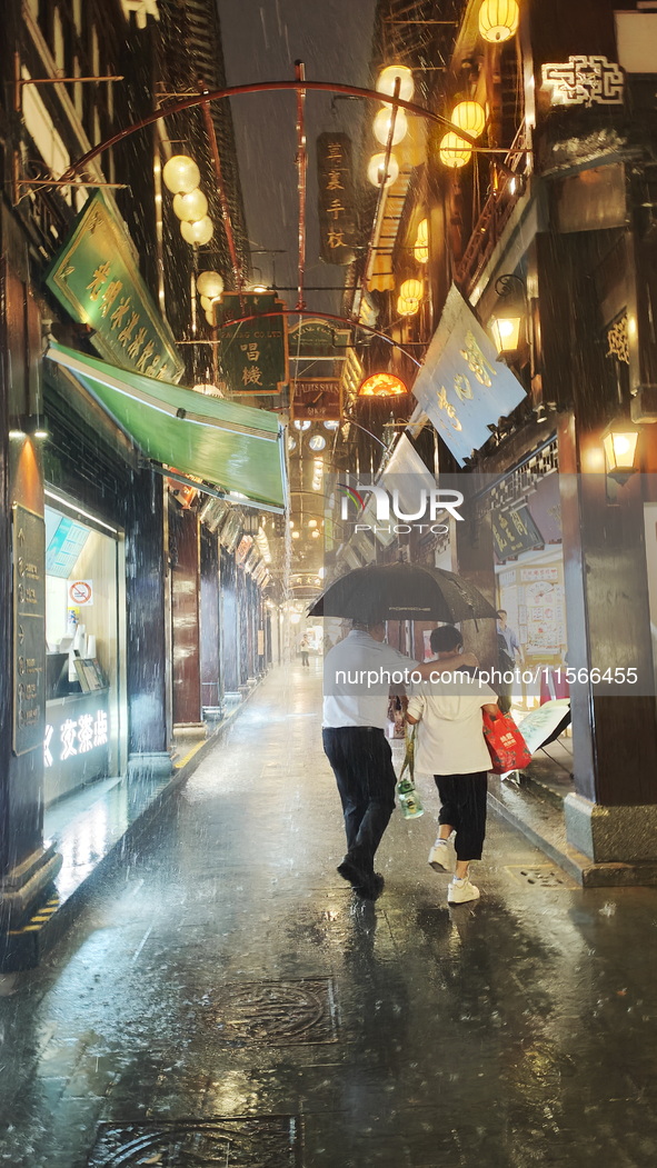 Tourists view the area amid heavy rain affected by a typhoon in Shanghai, China, on September 10, 2024. 