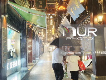 Tourists view the area amid heavy rain affected by a typhoon in Shanghai, China, on September 10, 2024. (