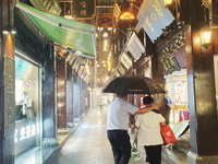 Tourists view the area amid heavy rain affected by a typhoon in Shanghai, China, on September 10, 2024. (