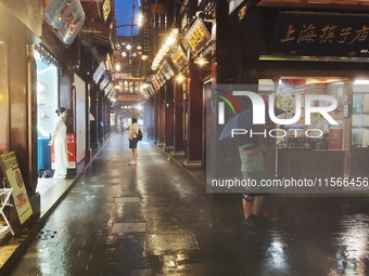 Tourists view the area amid heavy rain affected by a typhoon in Shanghai, China, on September 10, 2024. (