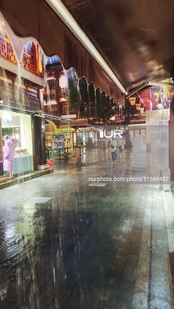 Tourists view the area amid heavy rain affected by a typhoon in Shanghai, China, on September 10, 2024. 