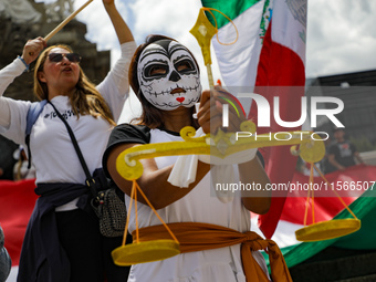 A woman participates in a protest at the Angel de la Independencia after the approval of the judicial reform to elect all judges by popular...