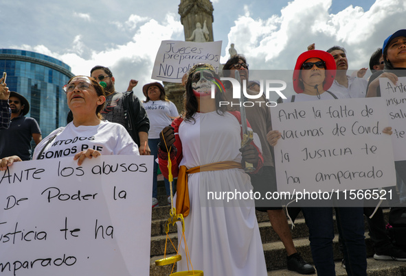 Judicial branch workers take part in a protest at the Angel de la Independencia after the approval of the judicial reform to elect all judge...