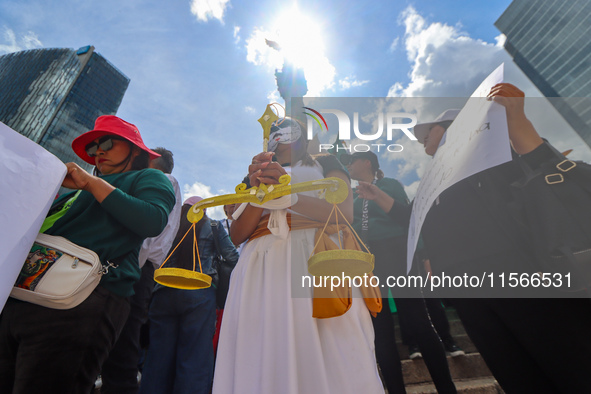 Judicial branch workers take part in a protest at the Angel de la Independencia after the approval of the judicial reform to elect all judge...