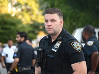 A police officer stands guard. The New York City Police Department investigates after a man is killed by a gunshot to the head in the East E...