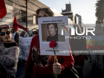 A person carries a photograph of a politically murdered person in a march commemorating the 51st anniversary of the coup in Chile. (