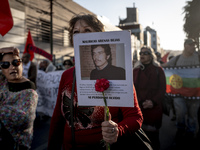 A person carries a photograph of a politically murdered person in a march commemorating the 51st anniversary of the coup in Chile. (