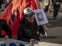 A person carries a photograph of a disappeared detainee in a march commemorating the 51st anniversary of the coup in Chile. (