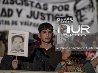 A person carries a photograph of a disappeared detainee in a march commemorating the 51st anniversary of the coup in Chile. (