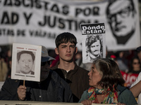 A person carries a photograph of a disappeared detainee in a march commemorating the 51st anniversary of the coup in Chile. (