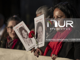 A person carries a photograph of a disappeared detainee in a march commemorating the 51st anniversary of the coup in Chile. (