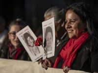 A person carries a photograph of a disappeared detainee in a march commemorating the 51st anniversary of the coup in Chile. (