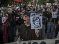 A person carries a photograph of a disappeared detainee in a march commemorating the 51st anniversary of the coup in Chile. (