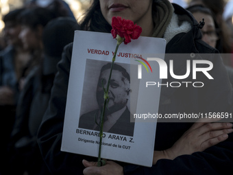 A person carries a photograph of a disappeared detainee in a march commemorating the 51st anniversary of the coup in Chile. (