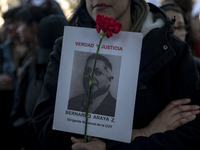 A person carries a photograph of a disappeared detainee in a march commemorating the 51st anniversary of the coup in Chile. (