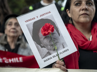 A person carries a photograph of a disappeared detainee in a march commemorating the 51st anniversary of the coup in Chile. (