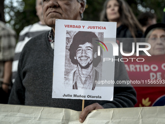 A person carries a photograph of a disappeared detainee in a march commemorating the 51st anniversary of the coup in Chile. (