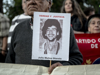 A person carries a photograph of a disappeared detainee in a march commemorating the 51st anniversary of the coup in Chile. (