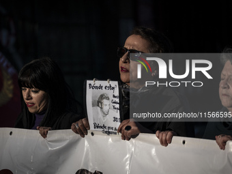 A person carries a photograph of a disappeared detainee in a march commemorating the 51st anniversary of the coup in Chile. (