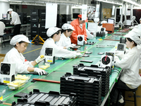 Workers rush to make computer and tablet battery orders at a workshop in Hai'an, China, on September 11, 2024. (