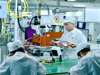 Workers rush to make computer and tablet battery orders at a workshop in Hai'an, China, on September 11, 2024. (