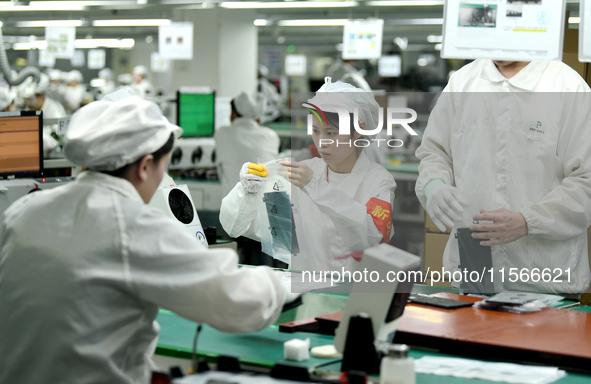 Workers rush to make computer and tablet battery orders at a workshop in Hai'an, China, on September 11, 2024. 